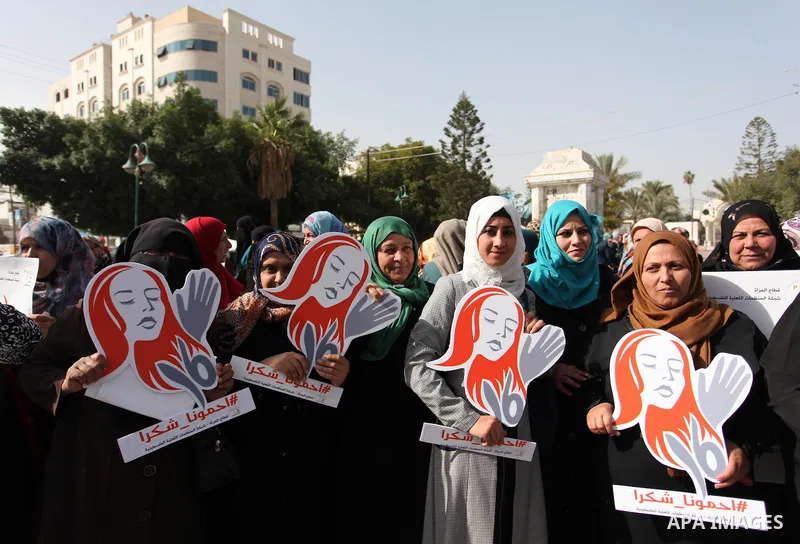 Palestinian women hold banners during international campaign against violence against women, in Gaza City, on November 24, 2016. Photo by Ashraf Amra