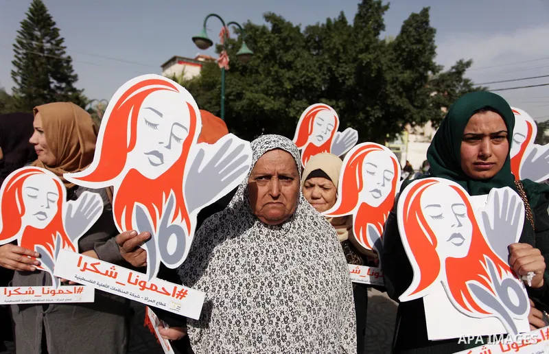 Palestinian women hold banners during international campaign against violence against women, in Gaza City, on November 24, 2016. Photo by Ashraf Amra