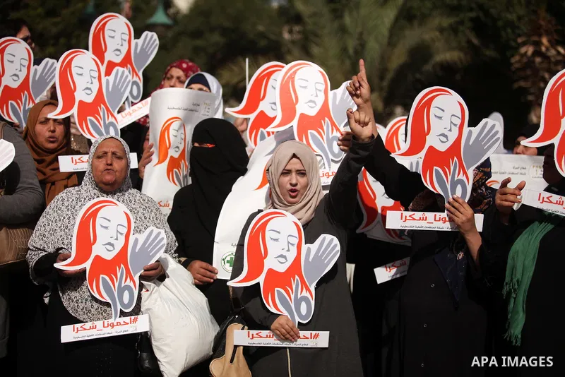 Palestinian women hold banners during international campaign against violence against women, in Gaza City, on November 24, 2016. Photo by Ashraf Amra