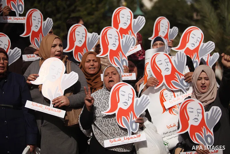 Palestinian women hold banners during international campaign against violence against women, in Gaza City, on November 24, 2016. Photo by Ashraf Amra