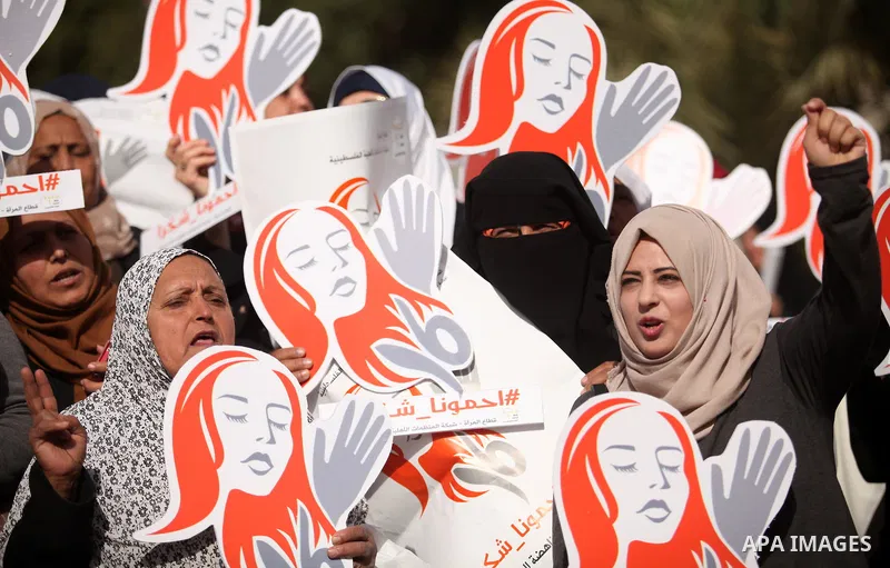 Palestinian women hold banners during international campaign against violence against women, in Gaza City, on November 24, 2016. Photo by Ashraf Amra