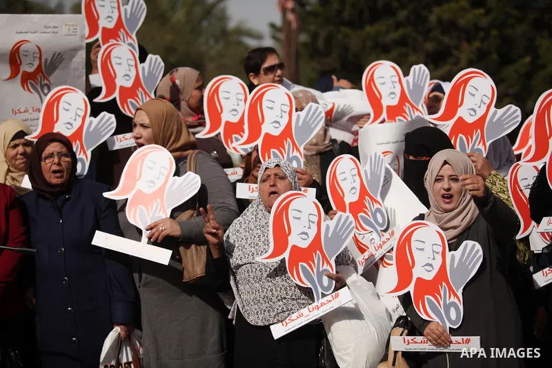 Palestinian women hold banners during international campaign against violence against women, in Gaza City, on November 24, 2016. Photo by Ashraf Amra