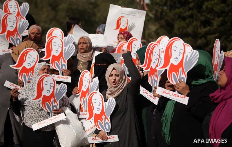 Palestinian women hold banners during international campaign against violence against women, in Gaza City, on November 24, 2016. Photo by Ashraf Amra