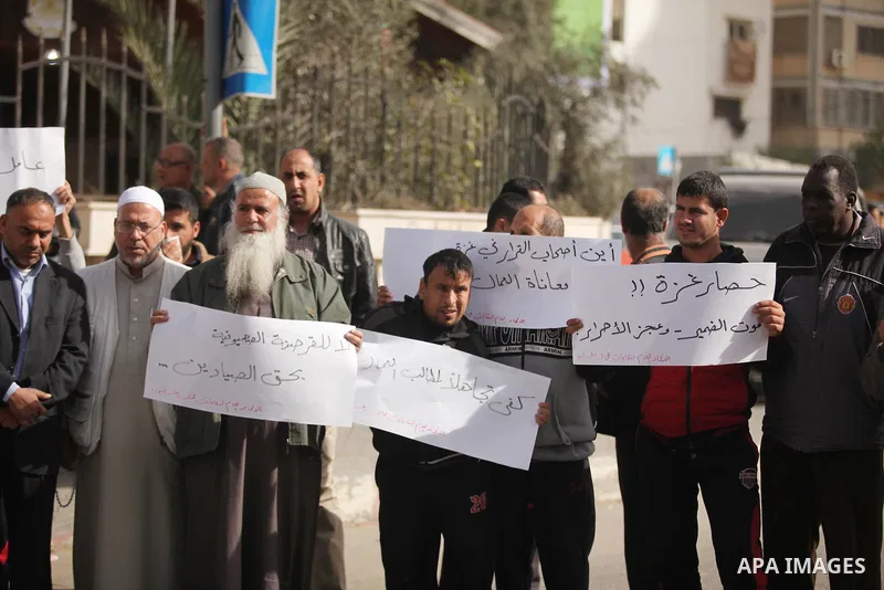 Palestinian workers hold banners during a protest demanding their rights in front of the Council of ministers headquarter, in Gaza city on November 24, 2016. Photo by Ashraf Amra