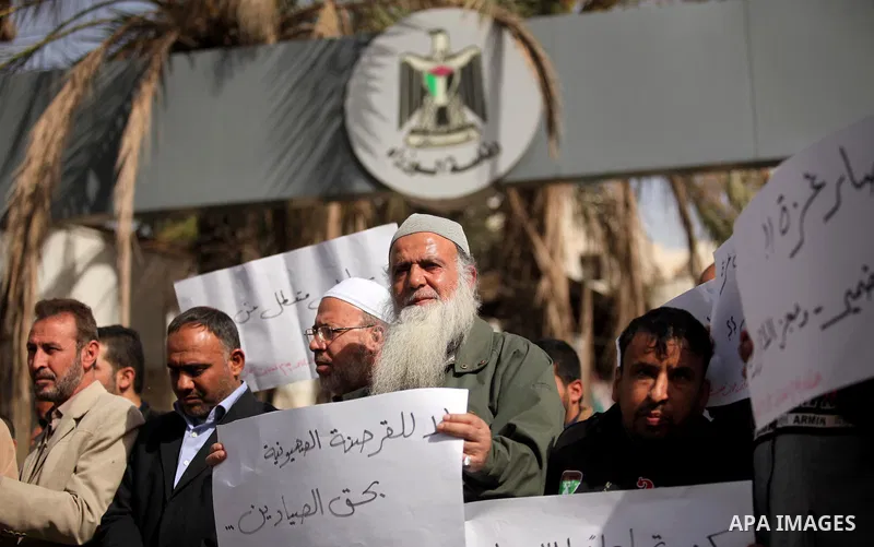 Palestinian workers hold banners during a protest demanding their rights in front of the Council of ministers headquarter, in Gaza city on November 24, 2016. Photo by Ashraf Amra
