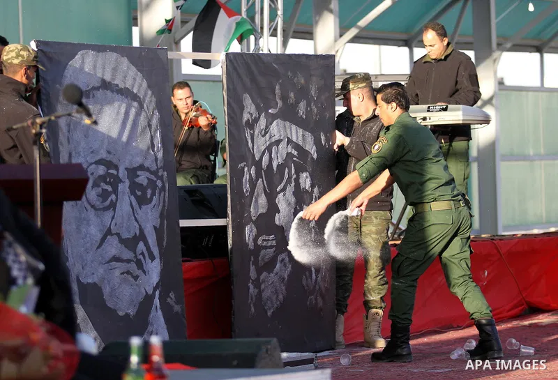Palestinian artist Mohammed al-Dairi paints a mural of late Palestinian leader Yasser Arafat in a mass wedding ceremony for 27 couples, supported by Palestinian President Mahmoud Abbas in the West Bank city of Jenin Nove...