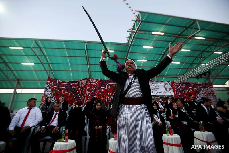 A Palestinian man dances in a mass wedding ceremony for 27 couples, supported by Palestinian President Mahmoud Abbas in the West Bank city of Jenin November 24, 2016. Photo by Nedal Eshtayah