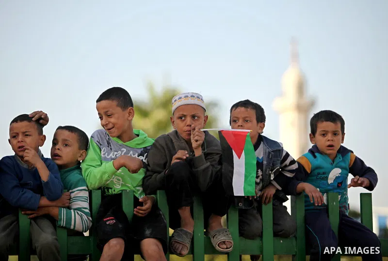 Palestinian boys watch Palestinian militants of the Hamas movement in a rally in Gaza city on November 25, 2016. Photo by Ashraf Amra