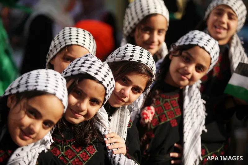 Palestinian girls watch Palestinian militants of the Hamas movement in a rally in Gaza city on November 25, 2016. Photo by Ashraf Amra