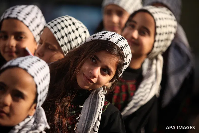 Palestinian girls watch Palestinian militants of the Hamas movement in a rally in Gaza city on November 25, 2016. Photo by Ashraf Amra