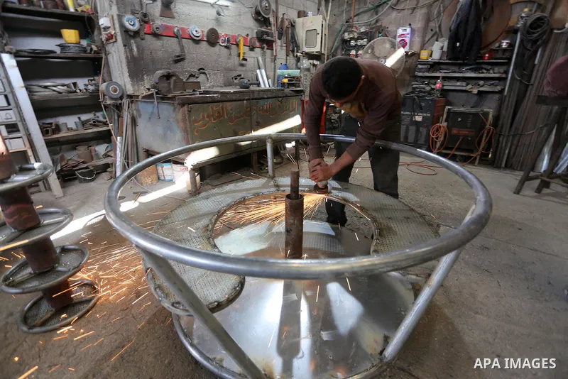Palestinian men work on the manufacture and maintenance of the swings "amusement games" at al-salam factory in the Zeitoun neighborhood, in Gaza city, on November 26, 2016. Israeli occupation prevented of the introductio...