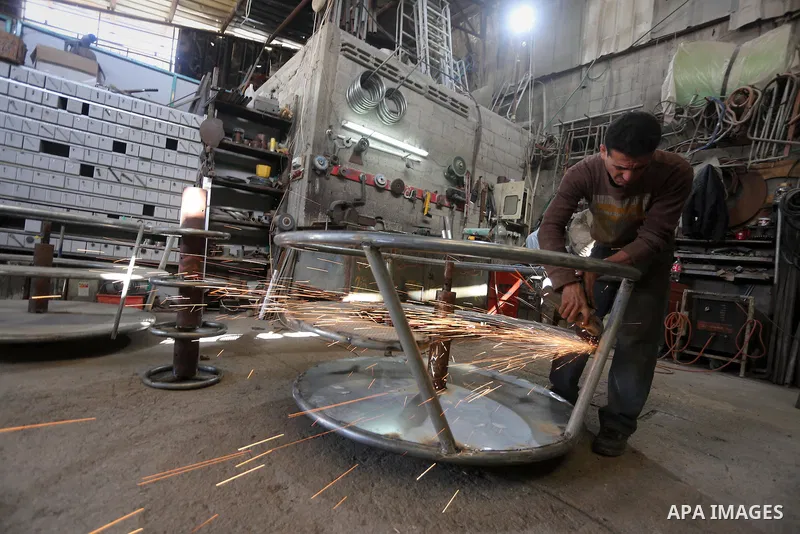 Palestinian men work on the manufacture and maintenance of the swings "amusement games" at al-salam factory in the Zeitoun neighborhood, in Gaza city, on November 26, 2016. Israeli occupation prevented of the introductio...