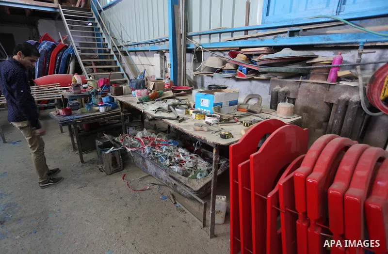 Palestinian men work on the manufacture and maintenance of the swings "amusement games" at al-salam factory in the Zeitoun neighborhood, in Gaza city, on November 26, 2016. Israeli occupation prevented of the introductio...