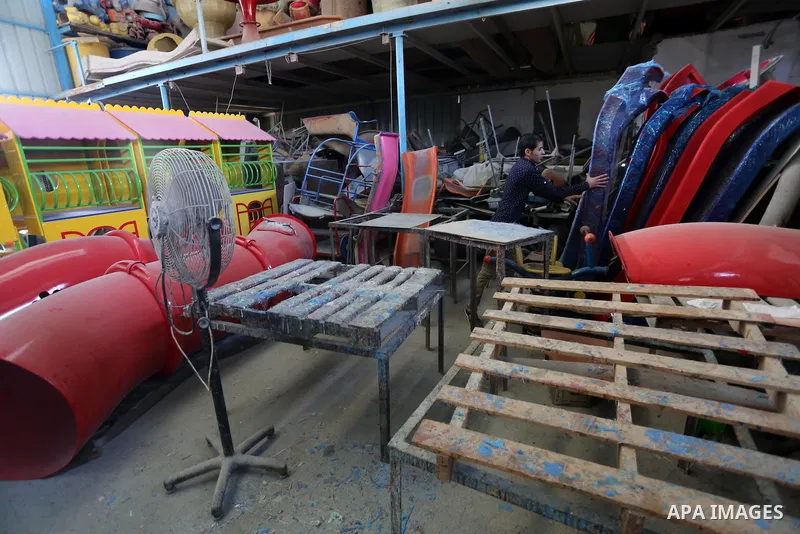 Palestinian men work on the manufacture and maintenance of the swings "amusement games" at al-salam factory in the Zeitoun neighborhood, in Gaza city, on November 26, 2016. Israeli occupation prevented of the introductio...