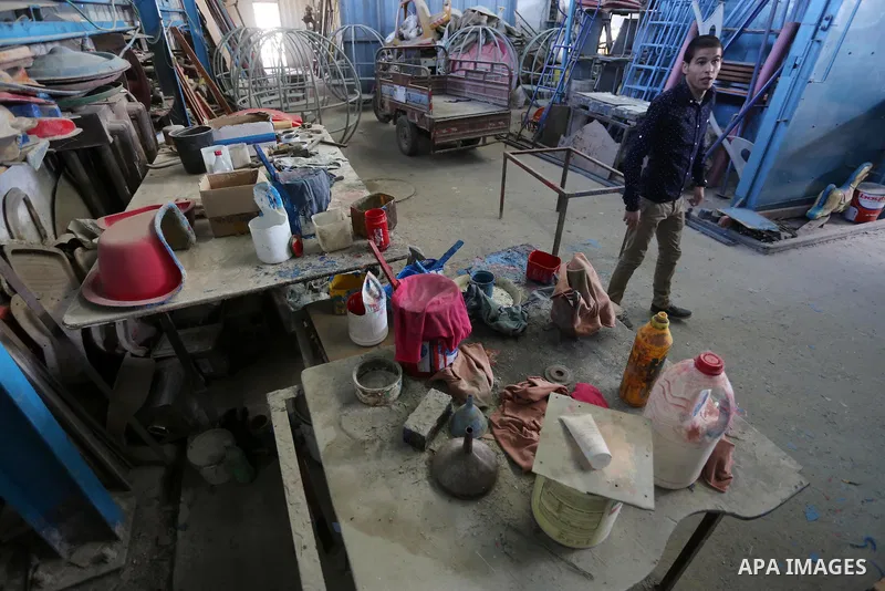 Palestinian men work on the manufacture and maintenance of the swings "amusement games" at al-salam factory in the Zeitoun neighborhood, in Gaza city, on November 26, 2016. Israeli occupation prevented of the introductio...