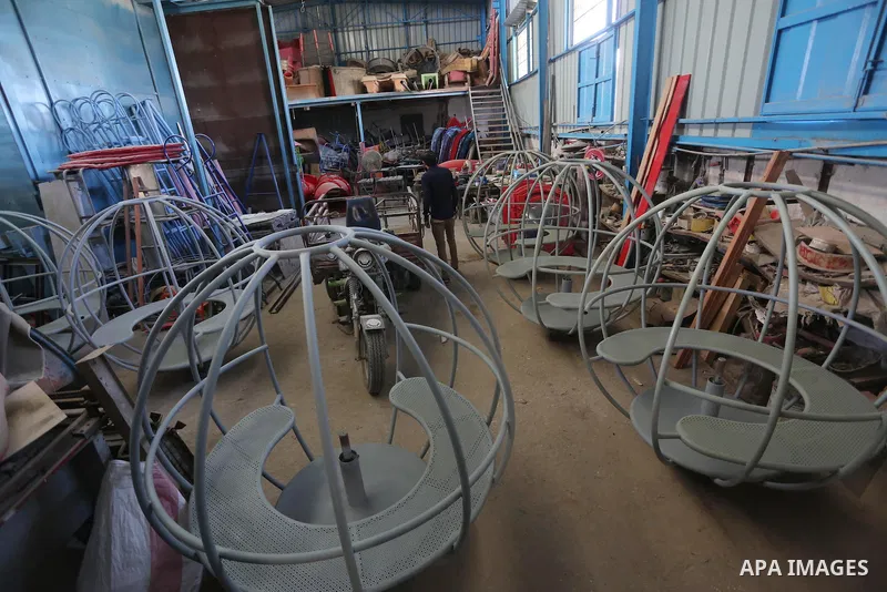 Palestinian men work on the manufacture and maintenance of the swings "amusement games" at al-salam factory in the Zeitoun neighborhood, in Gaza city, on November 26, 2016. Israeli occupation prevented of the introductio...