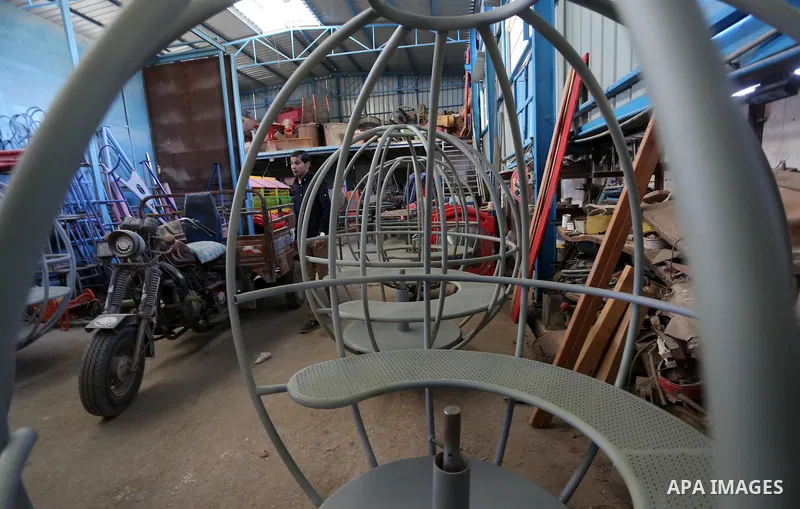 Palestinian men work on the manufacture and maintenance of the swings "amusement games" at al-salam factory in the Zeitoun neighborhood, in Gaza city, on November 26, 2016. Israeli occupation prevented of the introductio...