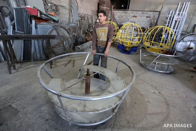 Palestinian men work on the manufacture and maintenance of the swings "amusement games" at al-salam factory in the Zeitoun neighborhood, in Gaza city, on November 26, 2016. Israeli occupation prevented of the introductio...