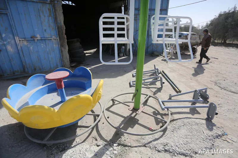 Palestinian men work on the manufacture and maintenance of the swings "amusement games" at al-salam factory in the Zeitoun neighborhood, in Gaza city, on November 26, 2016. Israeli occupation prevented of the introductio...