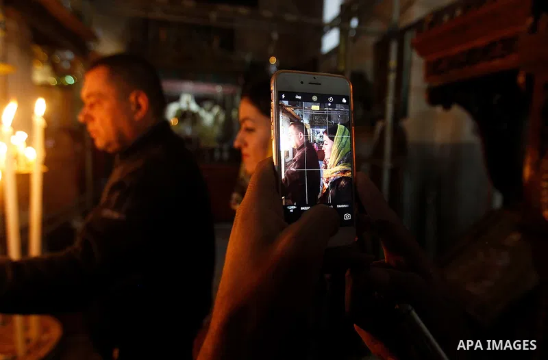 Christian worshipers light candles inside the Church of the Nativity in the West Bank city of Bethlehem November 26, 2016. Photo by Wisam Hashlamoun