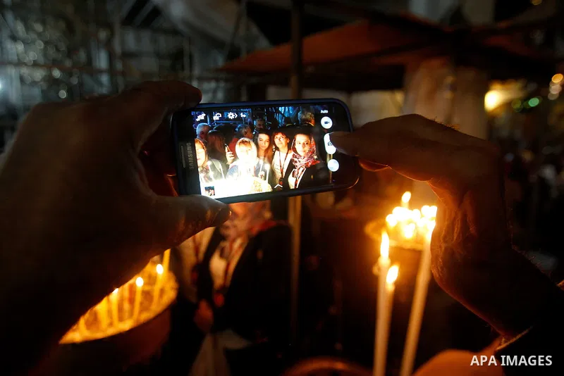 Christian worshipers light candles inside the Church of the Nativity in the West Bank city of Bethlehem November 26, 2016. Photo by Wisam Hashlamoun