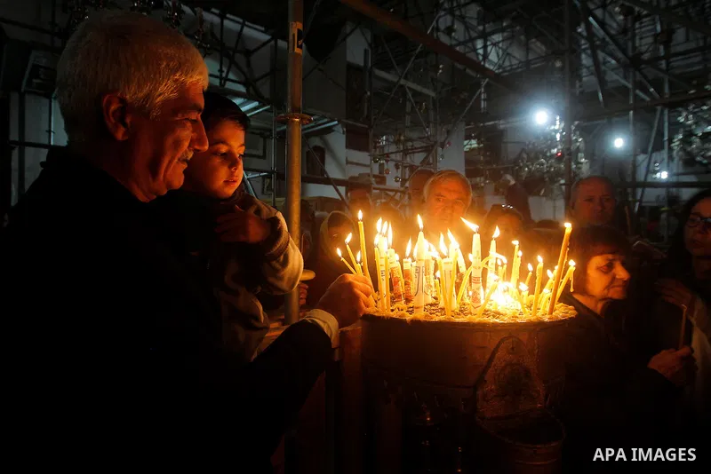 Christian worshipers light candles inside the Church of the Nativity in the West Bank city of Bethlehem November 26, 2016. Photo by Wisam Hashlamoun