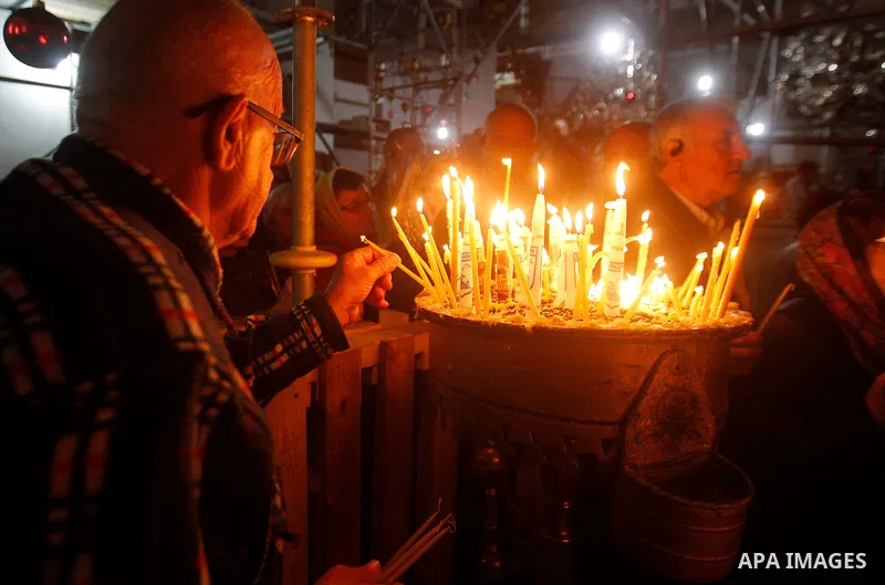 Christian worshipers light candles inside the Church of the Nativity in the West Bank city of Bethlehem November 26, 2016. Photo by Wisam Hashlamoun
