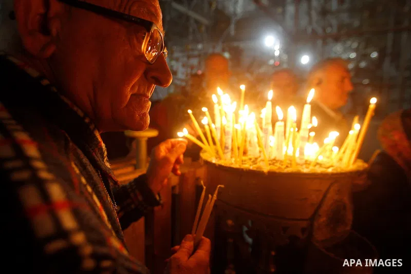 Christian worshipers light candles inside the Church of the Nativity in the West Bank city of Bethlehem November 26, 2016. Photo by Wisam Hashlamoun