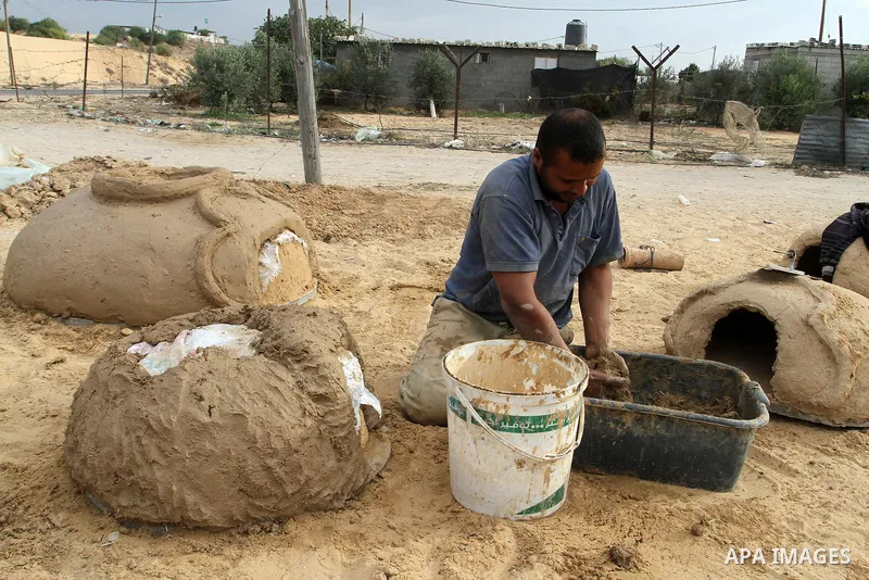 A Palestinian man, Iyad Abu Samhadana, prepares the clay ovens to earn their living, in Rafah in the southern Gaza Strip, on November 27, 2016. Photo by Abed Rahim Khatib