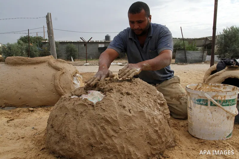 A Palestinian man, Iyad Abu Samhadana, prepares the clay ovens to earn their living, in Rafah in the southern Gaza Strip, on November 27, 2016. Photo by Abed Rahim Khatib