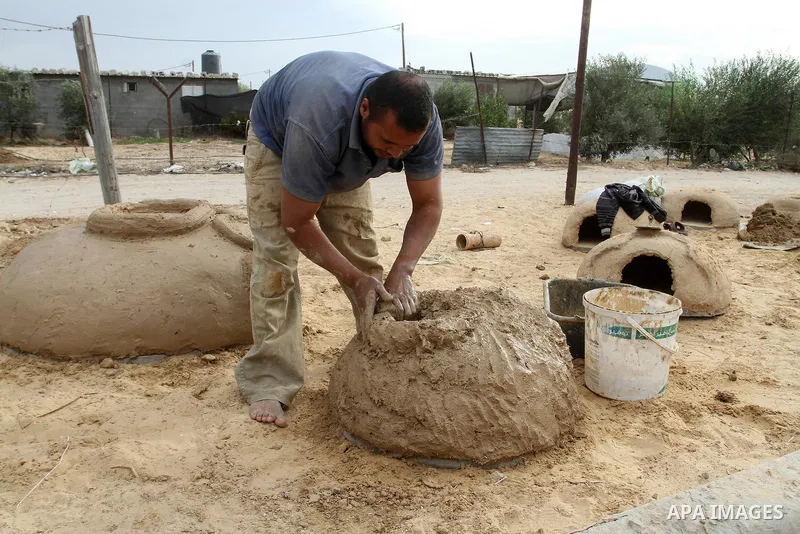 A Palestinian man, Iyad Abu Samhadana, prepares the clay ovens to earn their living, in Rafah in the southern Gaza Strip, on November 27, 2016. Photo by Abed Rahim Khatib