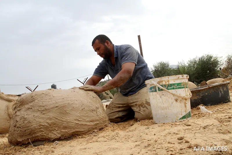 A Palestinian man, Iyad Abu Samhadana, prepares the clay ovens to earn their living, in Rafah in the southern Gaza Strip, on November 27, 2016. Photo by Abed Rahim Khatib