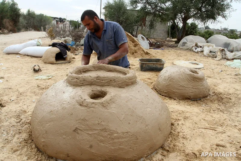 A Palestinian man, Iyad Abu Samhadana, prepares the clay ovens to earn their living, in Rafah in the southern Gaza Strip, on November 27, 2016. Photo by Abed Rahim Khatib