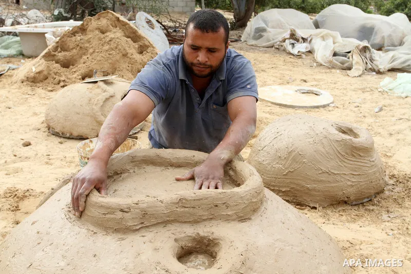 A Palestinian man, Iyad Abu Samhadana, prepares the clay ovens to earn their living, in Rafah in the southern Gaza Strip, on November 27, 2016. Photo by Abed Rahim Khatib
