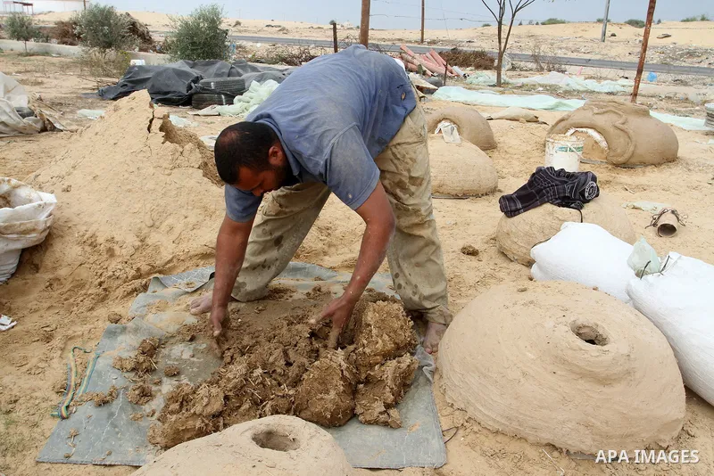 A Palestinian man, Iyad Abu Samhadana, prepares the clay ovens to earn their living, in Rafah in the southern Gaza Strip, on November 27, 2016. Photo by Abed Rahim Khatib