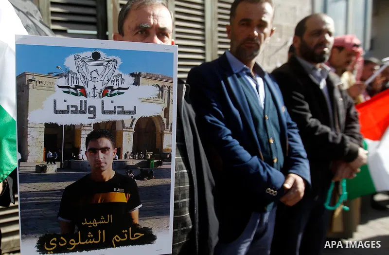 Palestinians hold banners during a protest demanding Israel return the bodies of Palestinians who allegedly stabbed Israelis, in the West Bank city of Hebron, on November 28, 2016. Photo by Wisam Hashlamoun