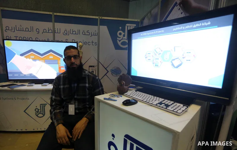 Palestinians attend to the Expotech exhibition for telecom and information technology, in Gaza City on November 30, 2016. Photo by Mohammed Asad
