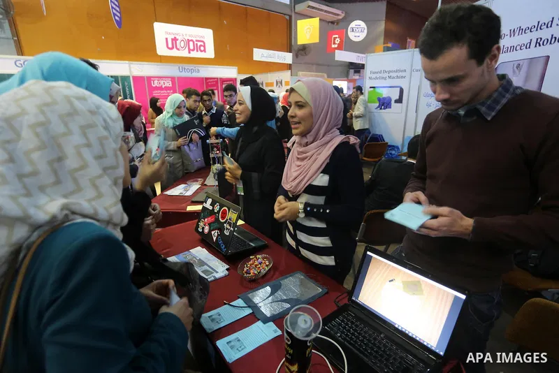 Palestinians attend to the Expotech exhibition for telecom and information technology, in Gaza City on November 30, 2016. Photo by Mohammed Asad