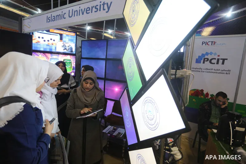 Palestinians attend to the Expotech exhibition for telecom and information technology, in Gaza City on November 30, 2016. Photo by Mohammed Asad