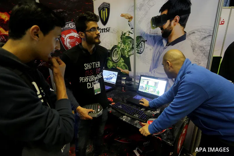 Palestinians attend to the Expotech exhibition for telecom and information technology, in Gaza City on November 30, 2016. Photo by Mohammed Asad