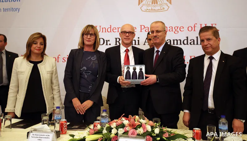 Palestinian Prime Minister Rami Hamdallah attends a ceremony of signing the PNIPH law, in the West Bank city of Ramallah, on Nov. 30, 2016. Photo by Prime Minister Office