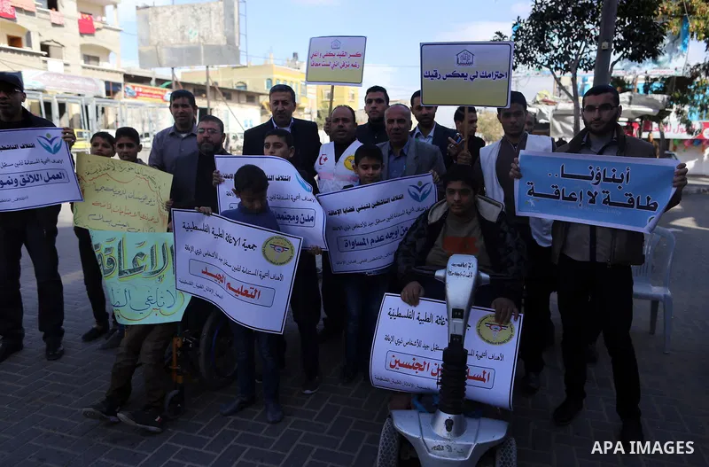 Palestinians and physically challenged people take part in a rally marking the International Day of Persons with Disabilities in Gaza City, on December 1, 2016. Photo by Yasser Qudih