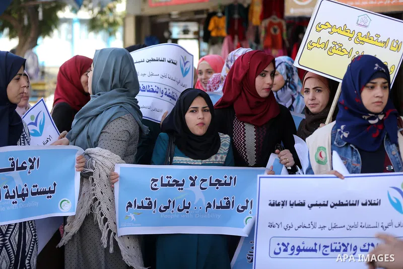Palestinians and physically challenged people take part in a rally marking the International Day of Persons with Disabilities in Gaza City, on December 1, 2016. Photo by Yasser Qudih