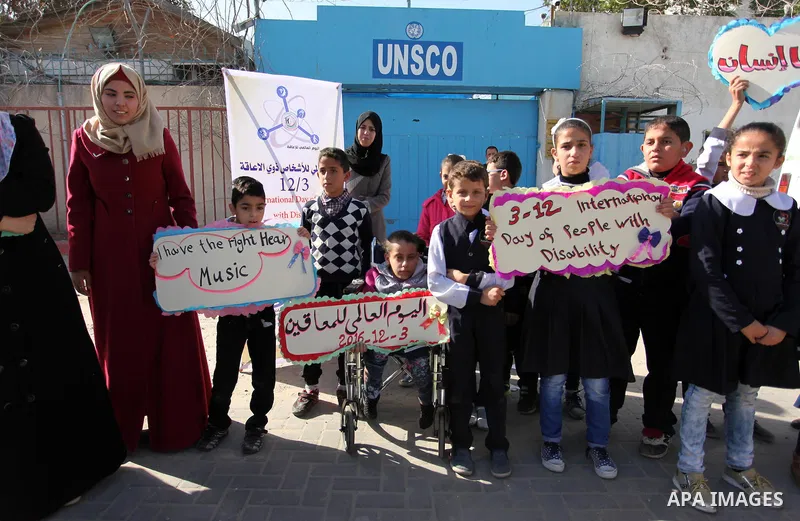 Palestinians and physically challenged people take part in a rally marking the International Day of Persons with Disabilities, outside the UNESCO headquarters in Gaza city, on December 1, 2016. Photo by Ashraf Amra