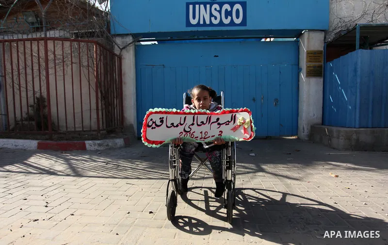 Palestinians and physically challenged people take part in a rally marking the International Day of Persons with Disabilities, outside the UNESCO headquarters in Gaza city, on December 1, 2016. Photo by Ashraf Amra