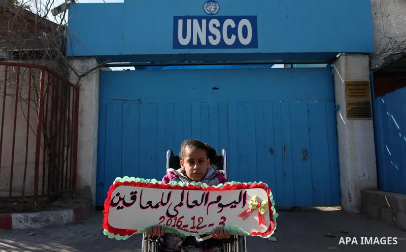 Palestinians and physically challenged people take part in a rally marking the International Day of Persons with Disabilities, outside the UNESCO headquarters in Gaza city, on December 1, 2016. Photo by Ashraf Amra