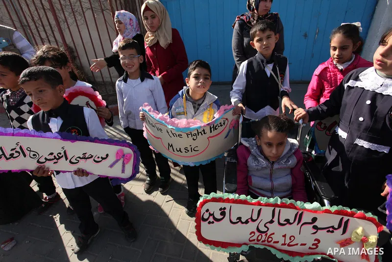 Palestinians and physically challenged people take part in a rally marking the International Day of Persons with Disabilities, outside the UNESCO headquarters in Gaza city, on December 1, 2016. Photo by Ashraf Amra