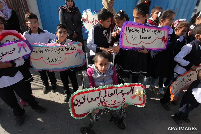 Palestinians and physically challenged people take part in a rally marking the International Day of Persons with Disabilities, outside the UNESCO headquarters in Gaza city, on December 1, 2016. Photo by Ashraf Amra