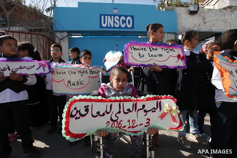 Palestinians and physically challenged people take part in a rally marking the International Day of Persons with Disabilities, outside the UNESCO headquarters in Gaza city, on December 1, 2016. Photo by Ashraf Amra