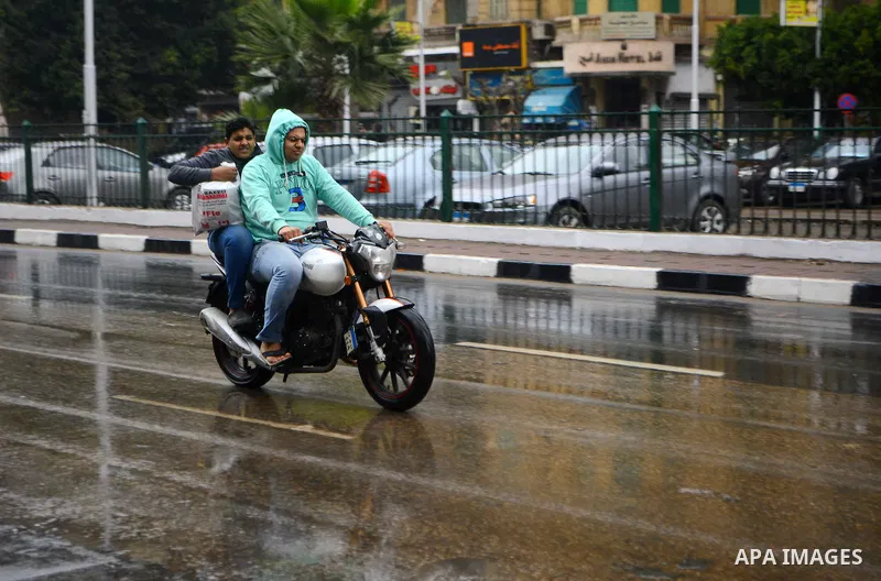 Egyptian men ride a motorcycle during rain and a cold spell over around country and the capital of Cairo, Egypt December 1, 2016. Photo by Amr Sayed